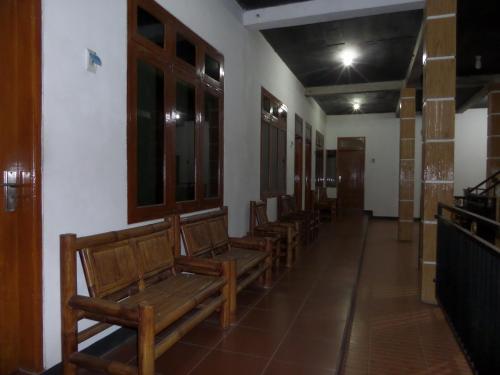 a row of wooden benches in a room at Kahyuna Guesthouse in Bromo