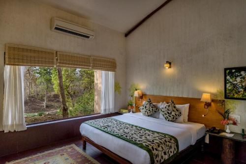 a bedroom with a large bed and a window at The Riverwood Forest Retreat Pench in Khawāsa