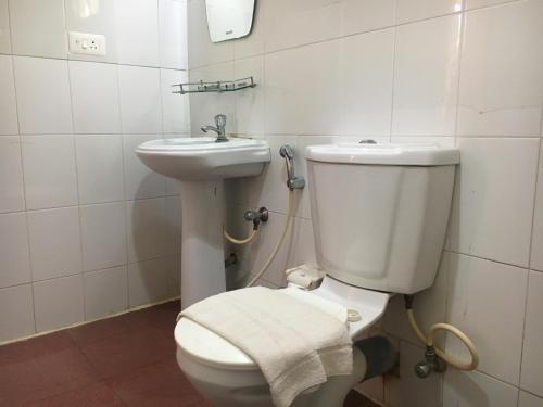 a bathroom with a white toilet and a sink at New Kovalam Beach Hotel in Kovalam