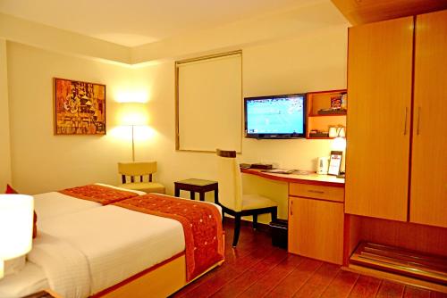 a hotel room with a bed and a desk with a computer at The Theme, Jaipur in Jaipur
