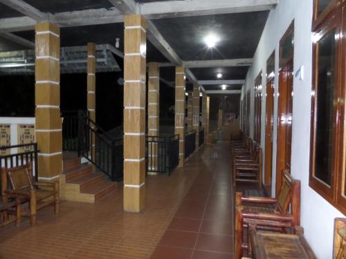 a hallway with columns and chairs in a building at Kahyuna Guesthouse in Bromo