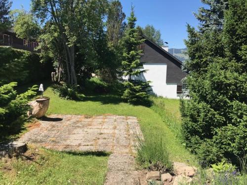 a yard with a house and a sign in the grass at Jizerka in Unterwasser