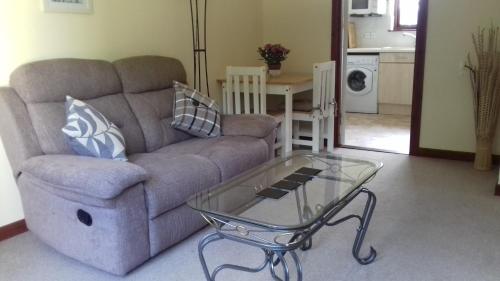 a living room with a couch and a glass coffee table at Culduthel Vista Apartment in Inverness