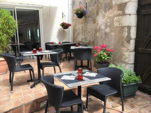 - un ensemble de tables et de chaises sur une terrasse dans l'établissement Hôtel Restaurant de la Place, à Saint-Jean-dʼAngély