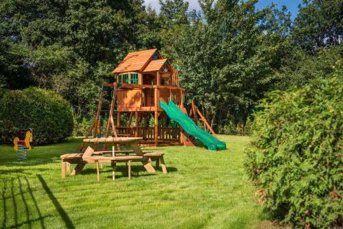 a playground with a tree house and a bench at Hotel Różany Gaj - Destigo Hotels in Gdynia