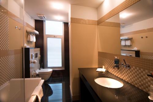 a bathroom with a sink and a toilet and a mirror at Art Hotel William in Bratislava