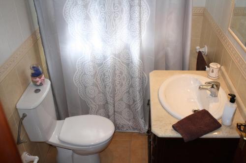 ガルダーにあるCasa El Salitreのバスルーム(トイレ、洗面台、シャワーカーテン付)