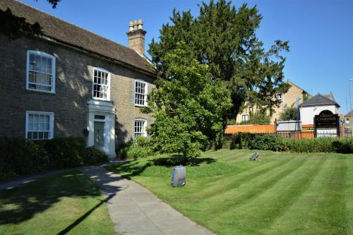 a large brick house with a grass yard at Oliver Cromwell Hotel in March