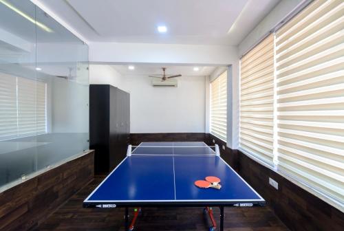 a ping pong table in a room with windows at The Riverwood Forest Retreat Pench in Khawāsa