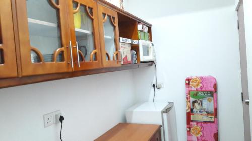 a kitchen with a wooden cabinet and a refrigerator at Sudarshi's Home in Mount Lavinia