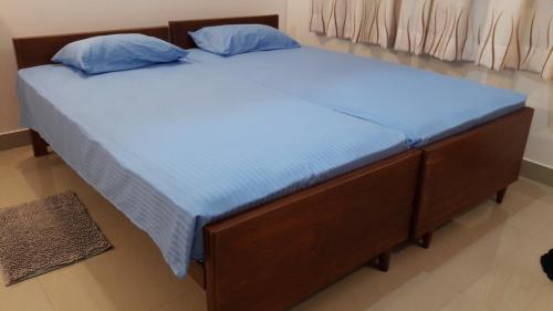 a bed with blue sheets and blue pillows on it at Sudarshi's Home in Mount Lavinia