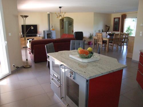 een keuken en een woonkamer met een fruitschaal op een aanrecht bij Chez Christiane Et Gerard in Orthez