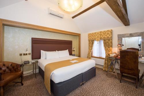 a hotel room with a large bed and a chair at Best Western Premier Doncaster Mount Pleasant Hotel in Doncaster