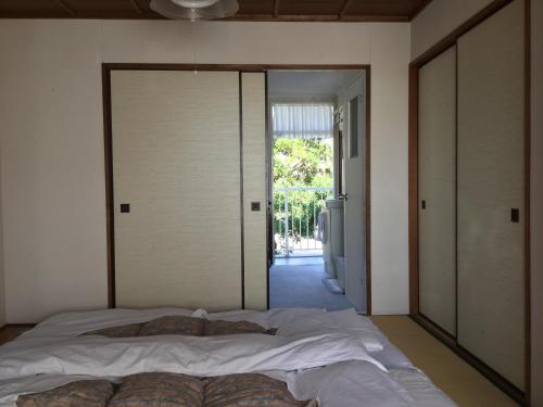 a bedroom with a large bed and a sliding glass door at Yuigahama Apart in Kamakura