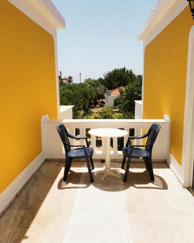 a patio with two chairs and a table on a balcony at Villa Aggeliki in Marathokampos