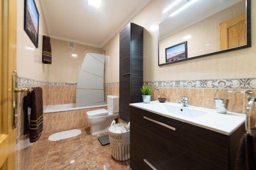 a bathroom with a sink and a toilet at Arinaga Luxury House Beach in Arinaga