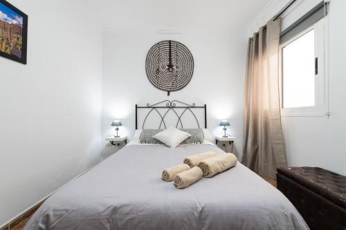 een witte slaapkamer met een groot bed met handdoeken erop bij Arinaga Luxury House Beach in Arinaga