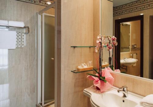 a bathroom with a sink and a toilet and a mirror at Grand Hotel Excelsior in Chianciano Terme