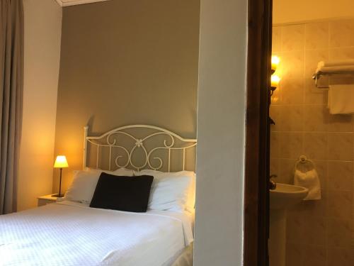 a bedroom with a white bed and a bathroom at Piccolo Mondo Hotel in Ağva