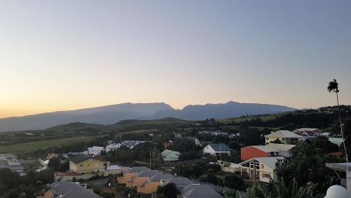a view of a town with mountains in the background at Hôtel Le Soleil Couchant in Saint-Pierre