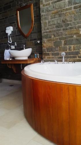a bathroom with a large tub and a sink at Hotel Restaurant Emblema in Petrelë