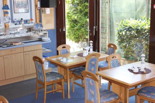 una cocina con mesas y sillas de madera y fregadero en Gästehaus Marek, en Nordenham