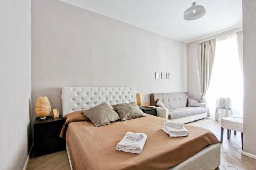 a white bedroom with a large bed and a couch at Vatican Heart in Rome