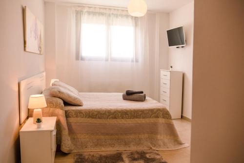 Habitación pequeña con cama y ventana en Apartamento Moderno, en Valladolid