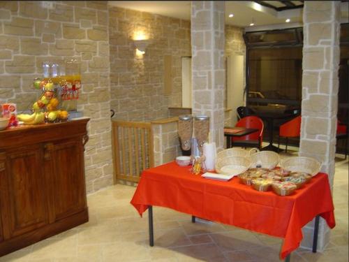 une table avec un tissu de table rouge et de la nourriture dans l'établissement Paris Hôtel Le Mediterraneen, à Paris