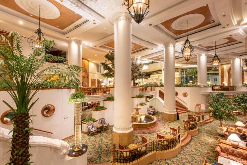 Montien Riverside Hotel Bangkok في بانكوك: لوبي فندق فيه اعمده ونباتات