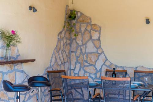 a restaurant with tables and chairs and a stone wall at Villa Dalmatian Gem in Gruda