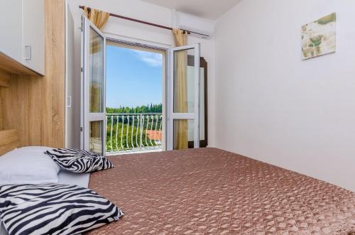 a bedroom with two beds and a large window at Villa Dalmatian Gem in Gruda