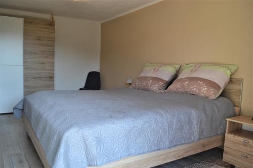 a bedroom with a bed with pink and white pillows at Apartmán pri Kalvárii in Banská Štiavnica