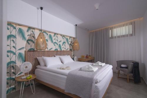a bedroom with a bed and a table with a chair at Harma Boutique Hotel in Hersonissos
