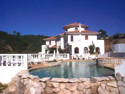 uma casa grande com uma piscina em frente em Quinta Da Mimosa em Monchique