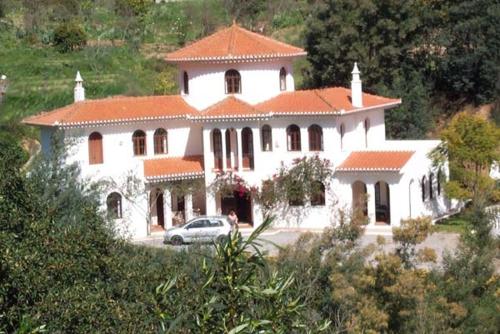 a large white house with a car in front of it at Quinta Da Mimosa in Monchique
