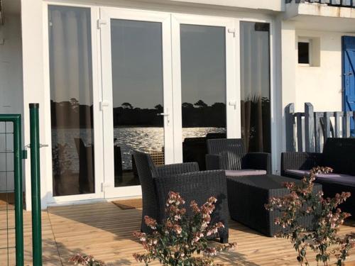 a patio with chairs and a table and windows at Appartement Du Lac in Hossegor
