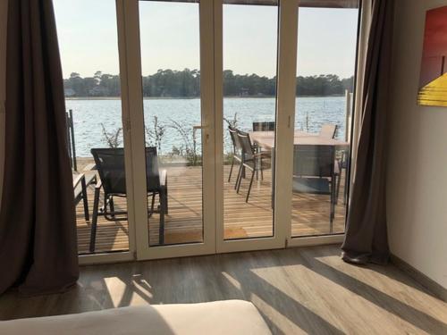 a room with sliding glass doors with a view of the water at Appartement Du Lac in Hossegor