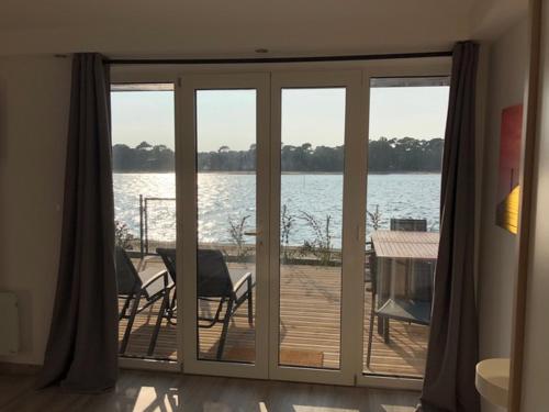 a room with a sliding glass door with a view of the water at Appartement Du Lac in Hossegor