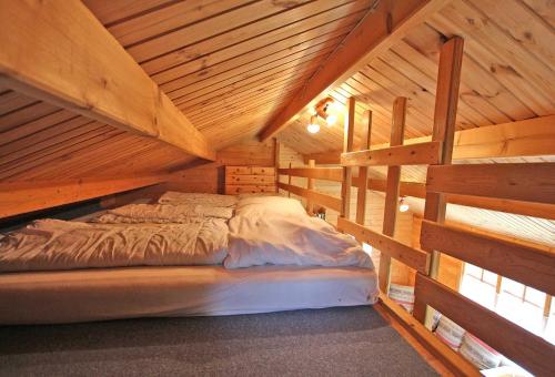 レヒリンにあるHolz_Ferienhaeuser Rechlin SEE 9800のキャビン内の木造の部屋のベッド1台