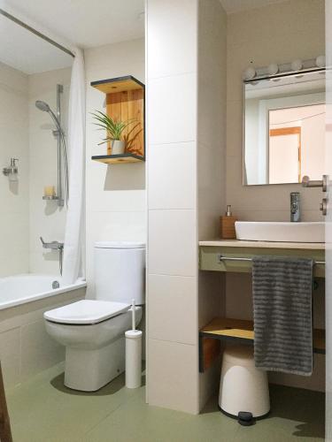a bathroom with a toilet and a sink and a mirror at Deltaic in Deltebre