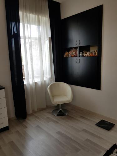 une chaise blanche assise dans une pièce avec fenêtre dans l'établissement guest house Telavi XXI, à Telavi