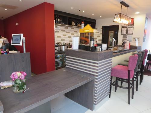 a bar in a restaurant with a counter and chairs at Ramada Bristol West in Easton in Gordano