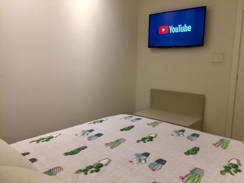 a bedroom with a bed with a white comforter and a television at Alla Riva in Verona