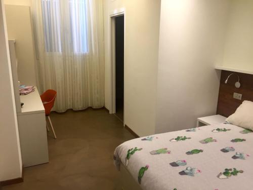 a hotel room with a bed and a desk and a window at Alla Riva in Verona