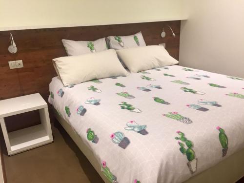 a bed with a white comforter on it with a table at Alla Riva in Verona