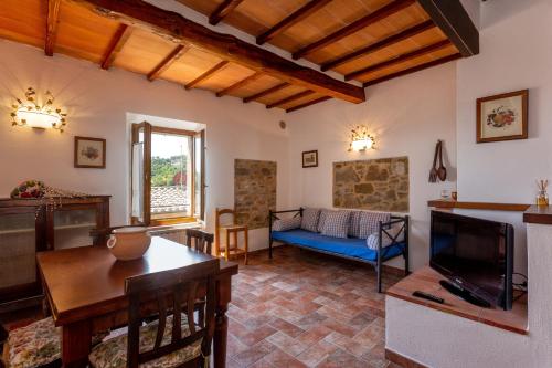 un soggiorno con divano e TV di Casa Vignolo a Montalcino