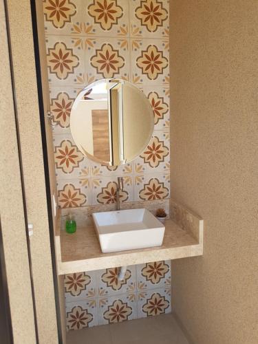 Un baño con un lavabo y un espejo en la pared. en Recanto da Tata, en Olímpia