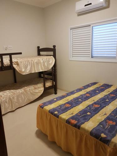 Un dormitorio con dos literas y una ventana. en Recanto da Tata, en Olímpia