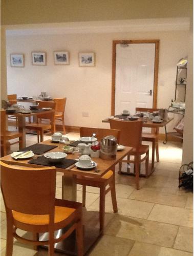 a dining room with wooden tables and chairs at Holly Lodge in Alnwick